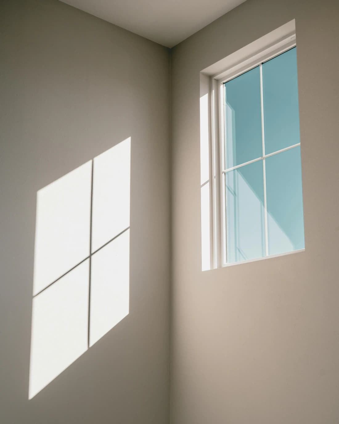 La luz del sol entra por una ventana y dibuja un cuadrado en la pared de una habitación